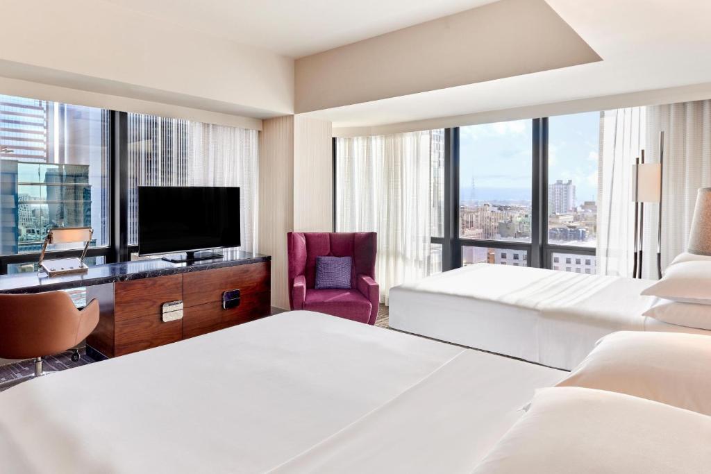 a hotel room with two beds and a flat screen tv at Sheraton Grand Los Angeles in Los Angeles
