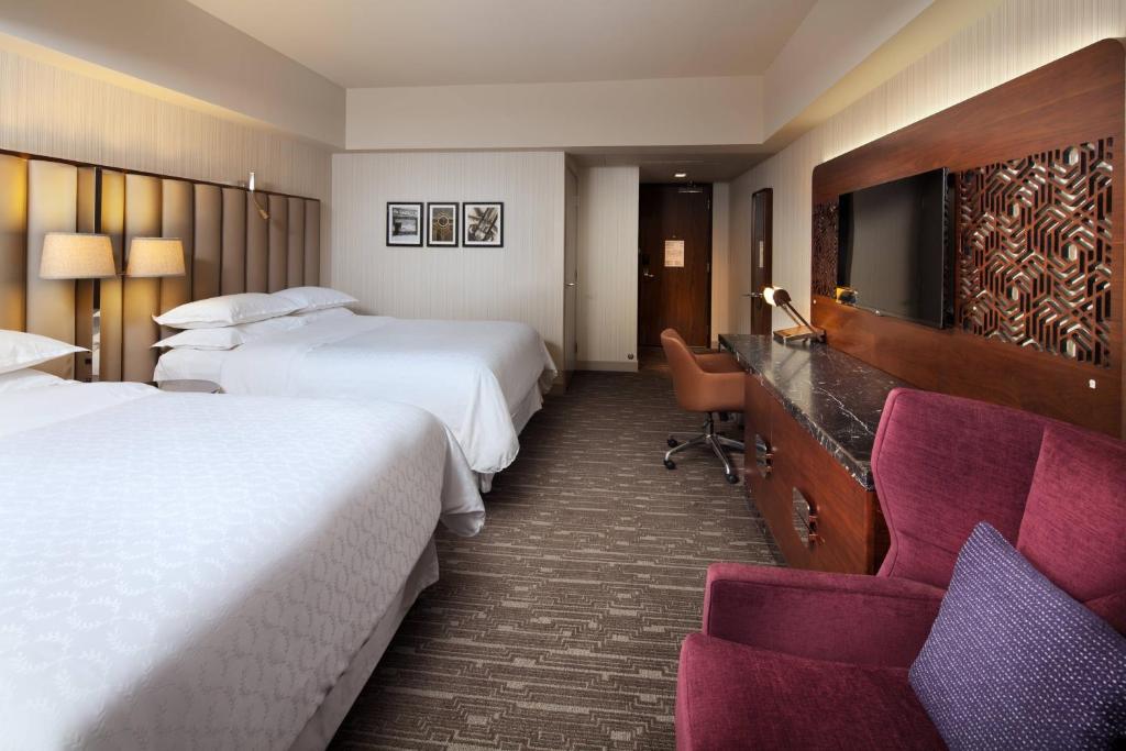 a hotel room with two beds and a chair at Sheraton Grand Los Angeles in Los Angeles