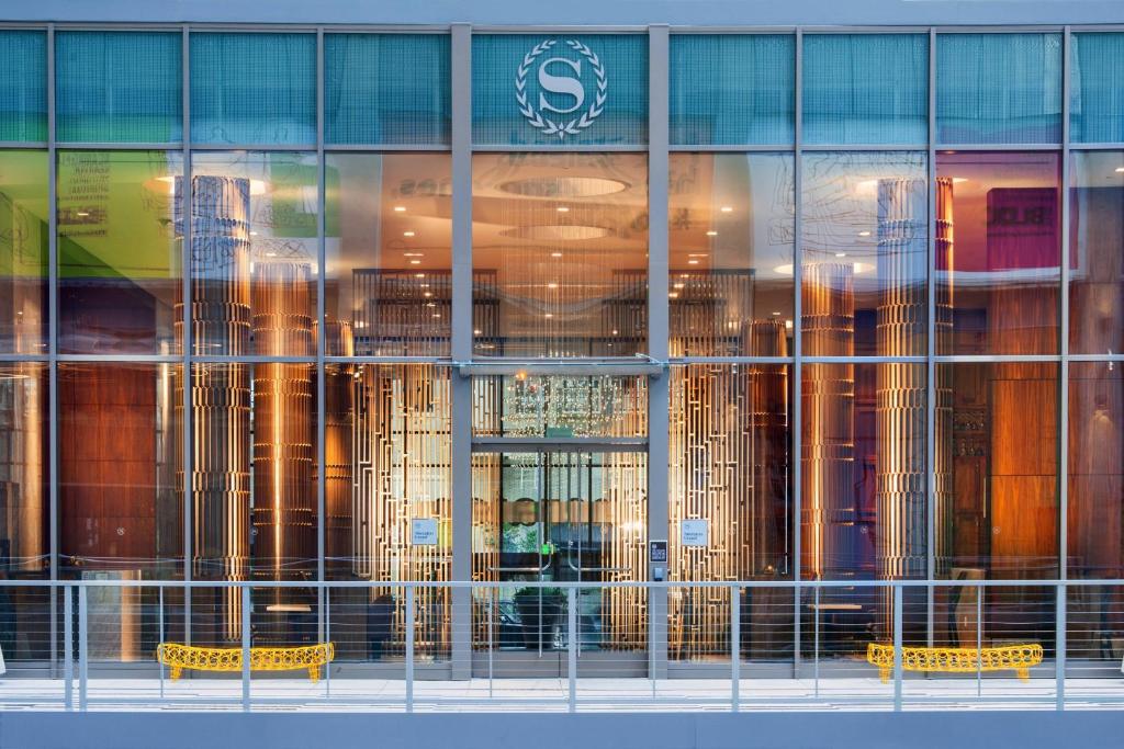 a glass window of a building with yellow benches in front at Sheraton Grand Los Angeles in Los Angeles