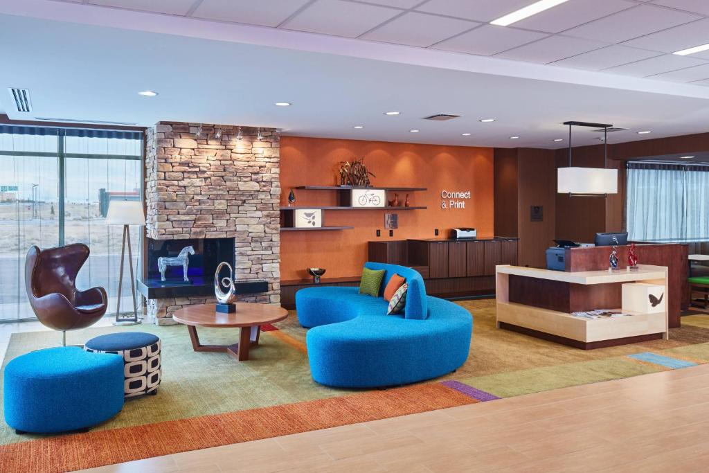 a lobby with blue chairs and a fireplace at Fairfield Inn & Suites by Marriott Rawlins in Rawlins