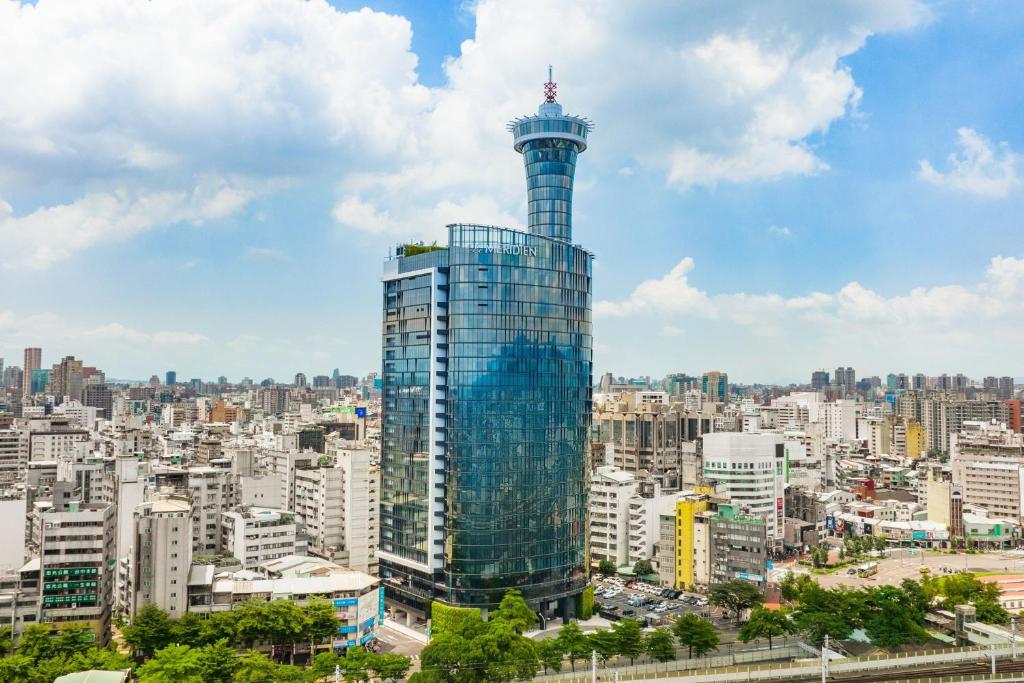 a tall glass building in a city at Le Méridien Taichung in Taichung