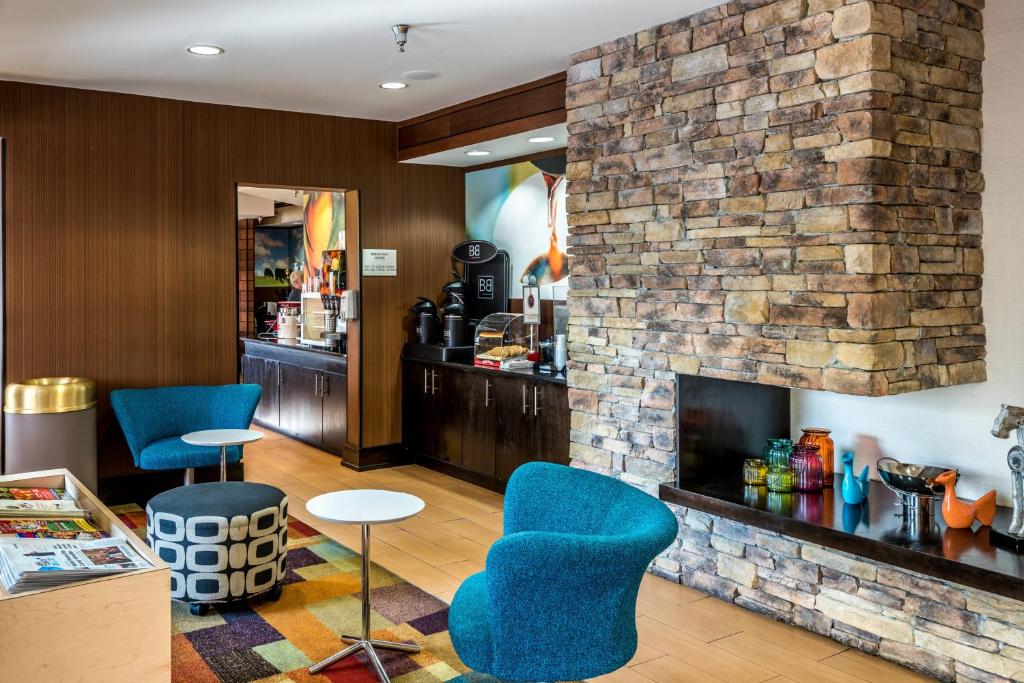 a lobby with blue chairs and a fireplace at Fairfield Inn & Suites Savannah I-95 South in Savannah