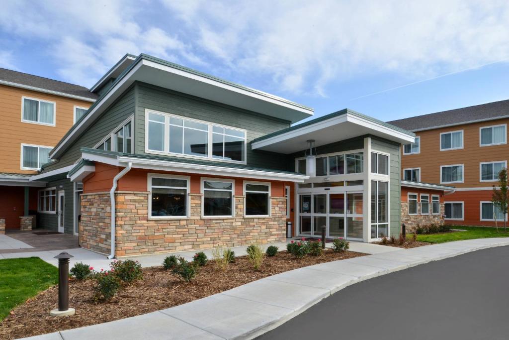 ein Haus mit einer Auffahrt vor einem Gebäude in der Unterkunft Residence Inn by Marriott East Lansing in East Lansing