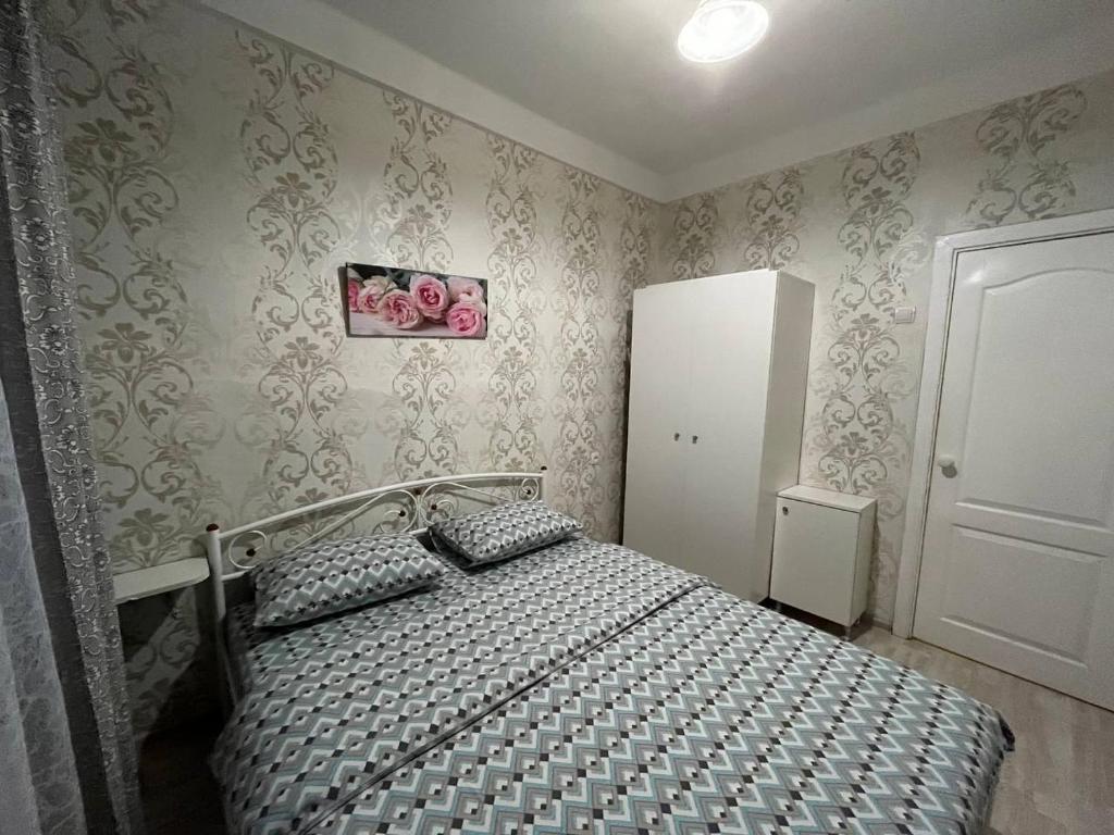 ein Schlafzimmer mit einem Bett in einem Zimmer mit Tapete in der Unterkunft 2к квартира Велика Васильківська 118, Палац Україна in Kiew