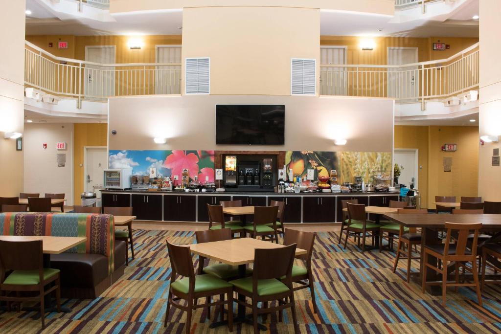 a restaurant with tables and chairs and a bar at Fairfield Inn & Suites Oakland Hayward in Hayward