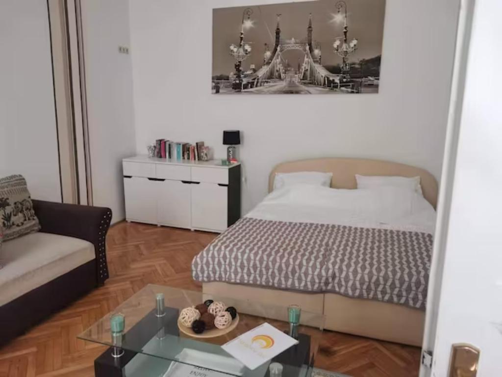 Schlafzimmer mit einem Bett und einem Couchtisch in der Unterkunft Sunshine flat at the BLAHA in Budapest