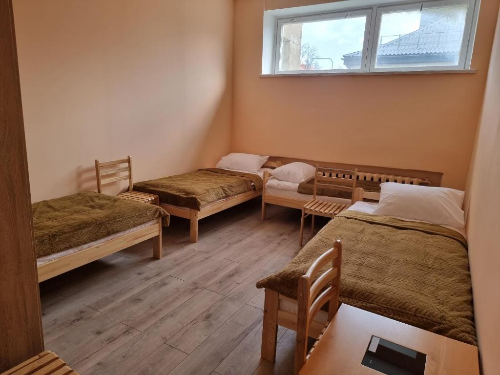 a room with three beds and a window at Hostel Kornealita in Zarasai