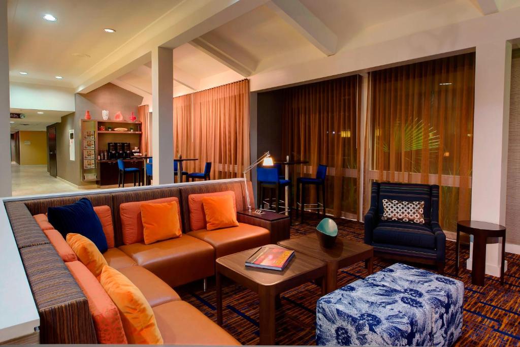 a living room with a couch and a table at Courtyard Houston/Brookhollow in Houston