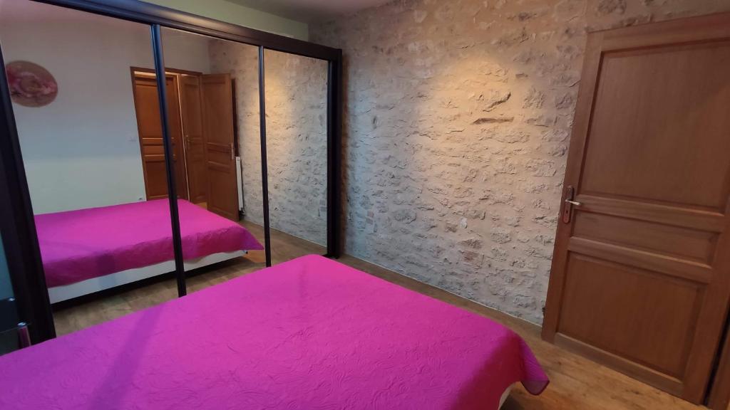 Sauzet的住宿－Appartement Victoria，配有粉红色的床和镜子的房间