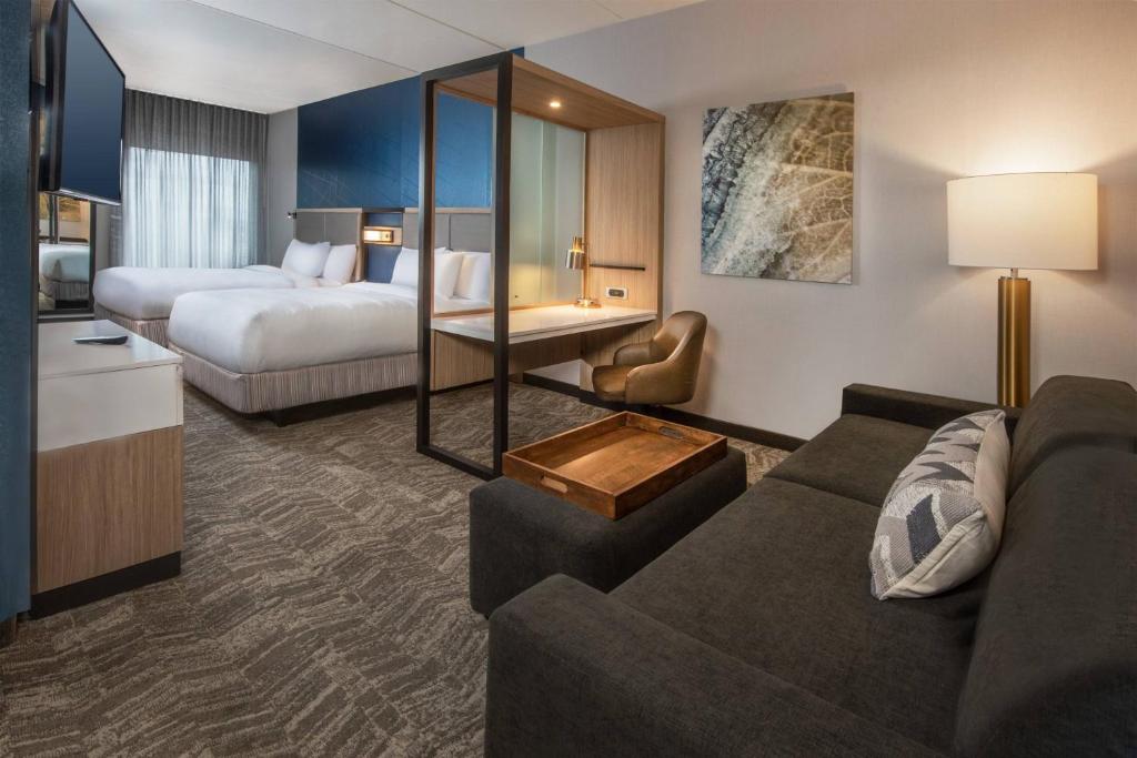 フレデリックにあるSpringHill Suites By Marriott Frederickのソファとベッド付きのホテルルーム