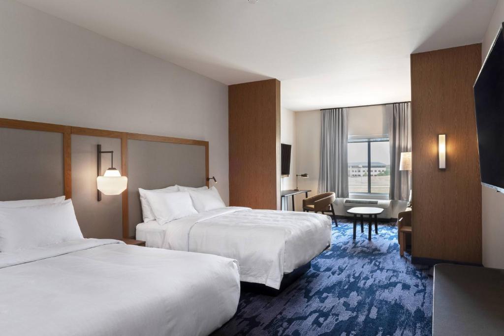 um quarto de hotel com duas camas e uma mesa em Fairfield by Marriott Inn and Suites O Fallon IL em O'Fallon