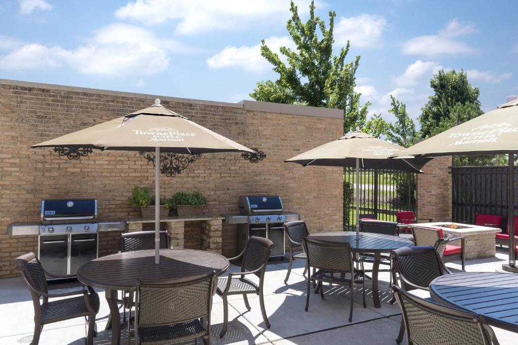 un patio avec des tables, des chaises et des parasols dans l'établissement TownePlace Suites Joliet South, à Joliet