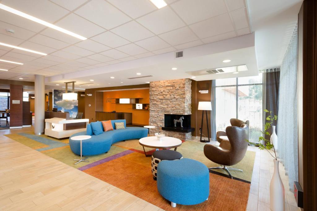 sala de estar con sofá azul y sillas en Fairfield Inn & Suites by Marriott Decorah en Decorah