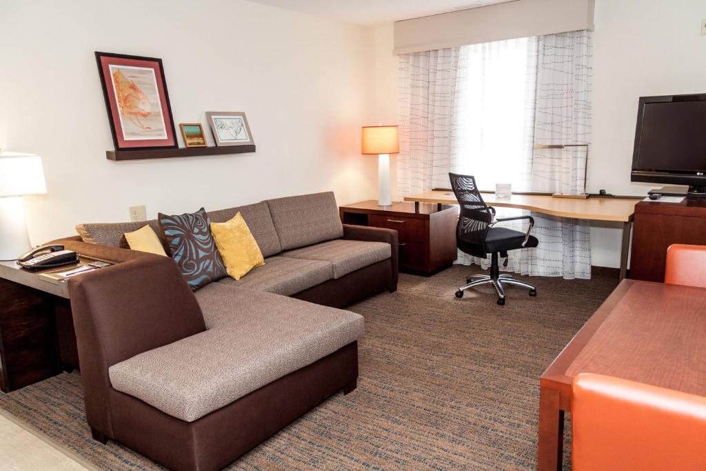 een woonkamer met een bank en een bureau bij Residence Inn by Marriott Rocky Mount in Rocky Mount