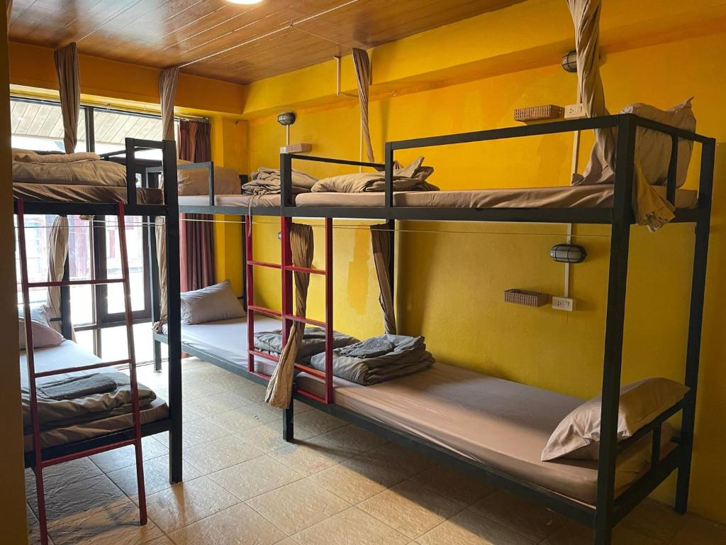 a room with three bunk beds in a room at Over the Moon hostel in Ban Houayxay