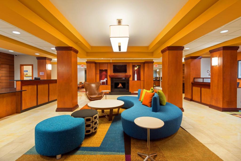 a lobby of a hotel with blue chairs and tables at Fairfield Inn & Suites Louisville Downtown in Louisville
