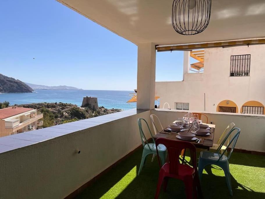 una mesa y sillas en un balcón con vistas al océano en Balcón al mediterráneo en Almuñécar