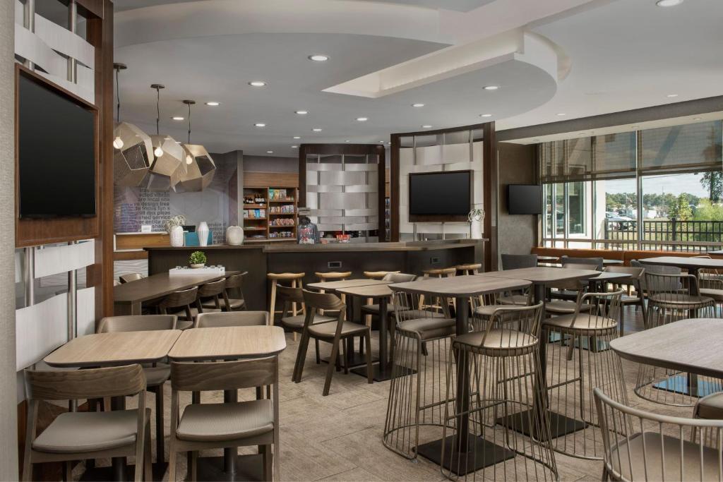 SpringHill Suites by Marriott Tuscaloosa في توسكالوسا: مطعم بطاولات وكراسي وبار