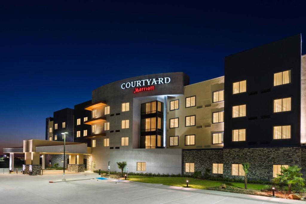 a view of a court yard hotel at night at Courtyard by Marriott Houston Katy Mills in Katy