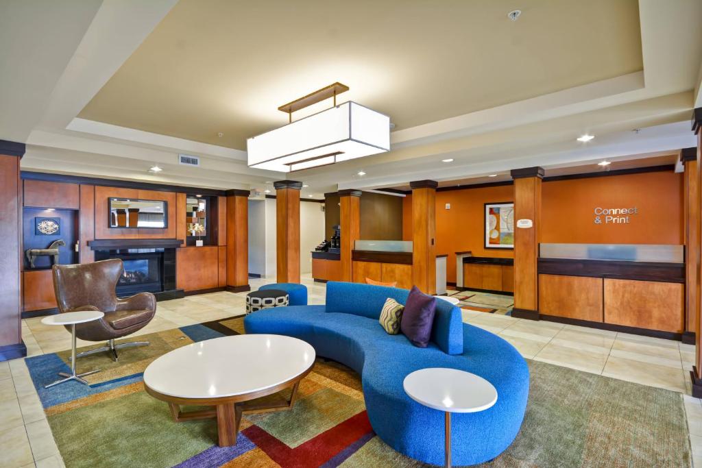 a lobby with a blue couch and a table and chairs at Fairfield Inn & Suites Tampa Fairgrounds/Casino in Tampa