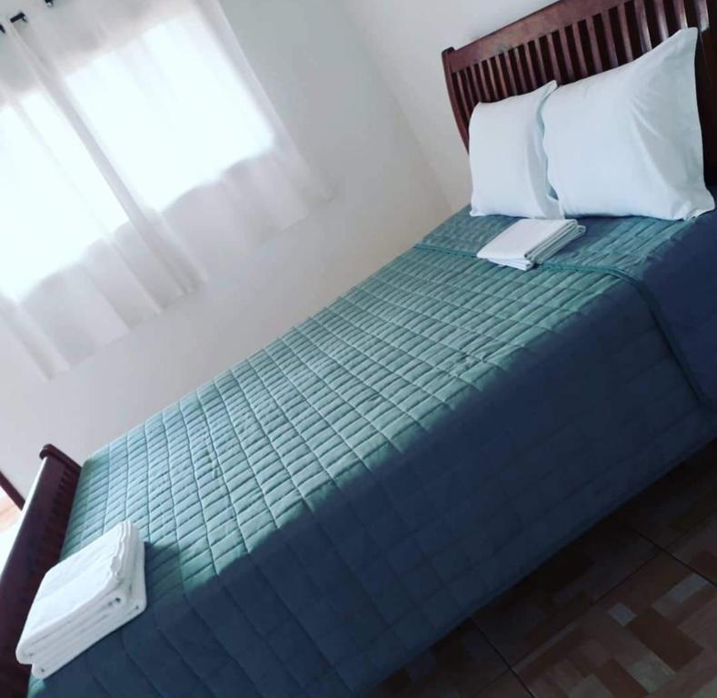a bedroom with a bed with a blue comforter at Pousada Nativos in Baía Formosa