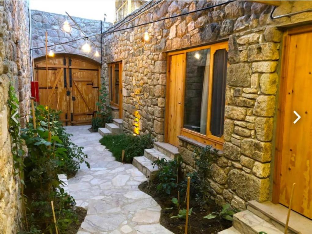une maison en pierre avec une passerelle menant à une porte dans l'établissement Hotel Room Close to Assos Ancient City in Ayvacik, à Sazlı