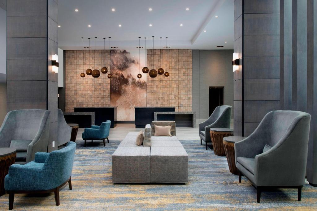 a lobby with chairs and a couch and tables at Delta Hotels by Marriott Seattle Everett in Everett