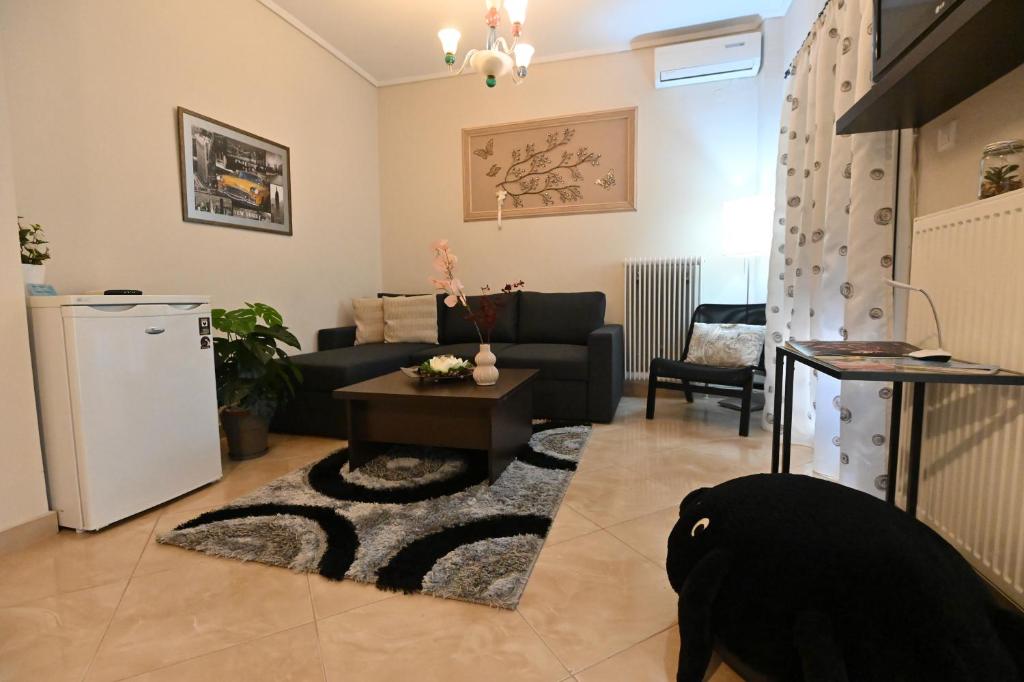 uma sala de estar com um sofá e uma mesa em Cozy Apartment Νear Nea Paralia of Thessaloniki em Tessalônica