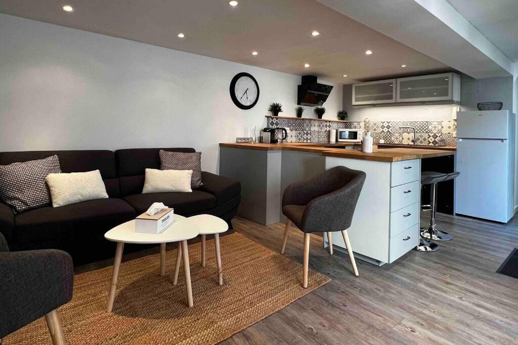 ein Wohnzimmer mit einem Sofa und einem Tisch sowie eine Küche in der Unterkunft La Petite Rochambelle (hyper centre-ville) in Vendôme