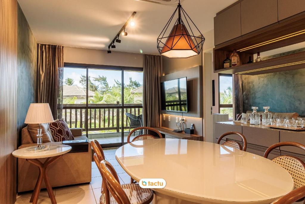 une cuisine et une salle à manger avec une table et des chaises dans l'établissement Bungalow face jardin au VG Sun Cumbuco par Tactu, à Paracumbuca