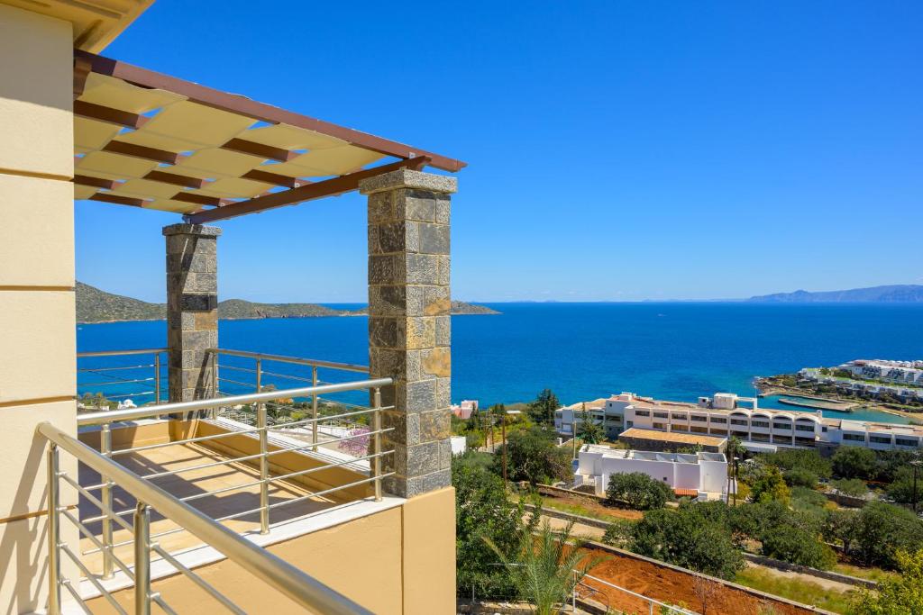 a balcony with a view of the ocean at Elounda Blue Waves Residence in Elounda