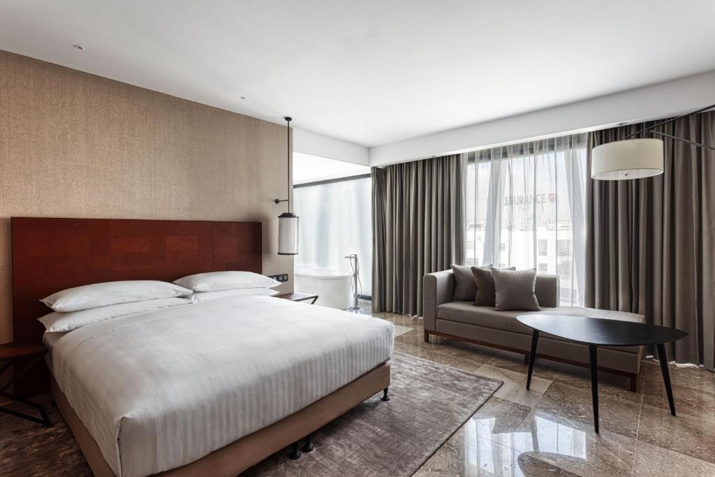 una camera con un grande letto e un divano di Tunis Marriott Hotel a Tunisi