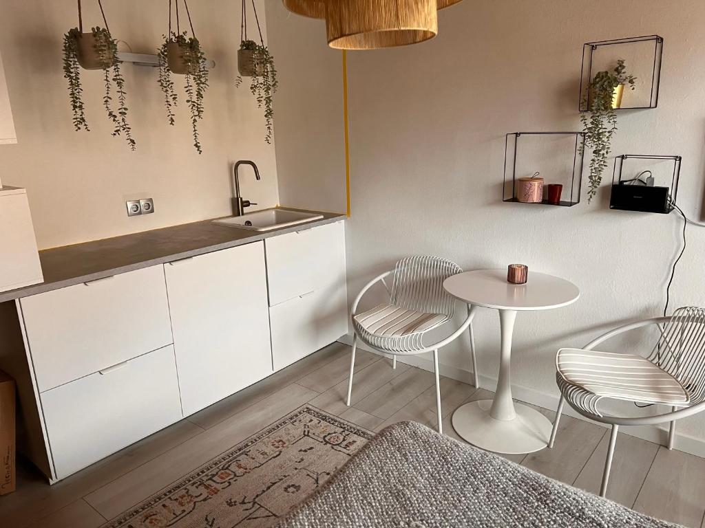 cocina con mesa, sillas y fregadero en Modernes Apartment “Traum“ en Mehlmeisel