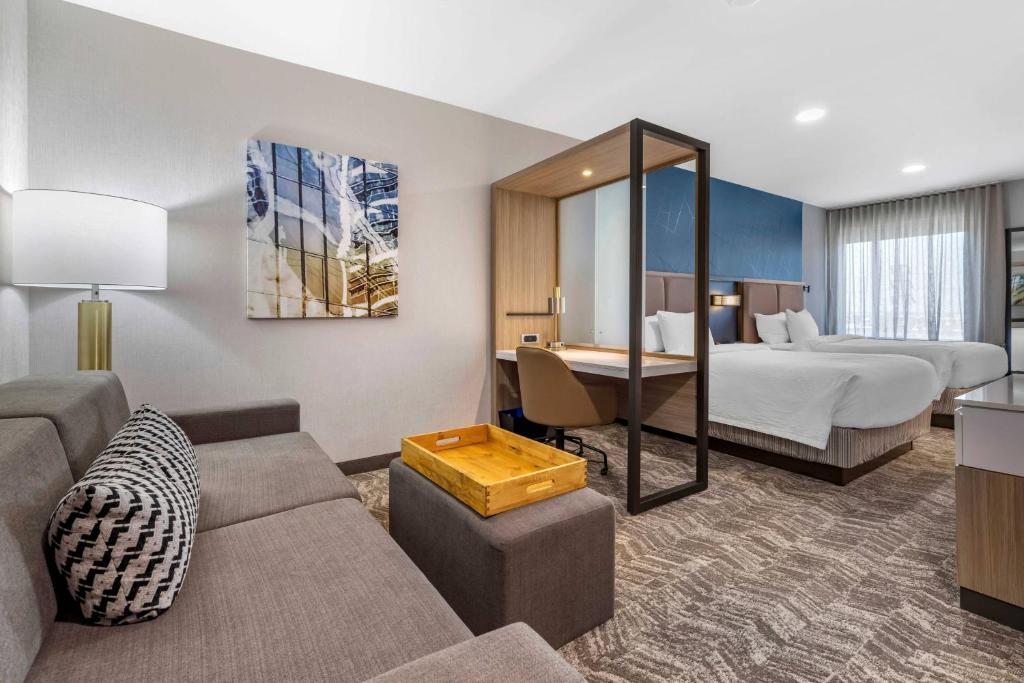 une chambre d'hôtel avec un canapé et un lit dans l'établissement SpringHill Suites by Marriott Anaheim Placentia Fullerton, à Placentia