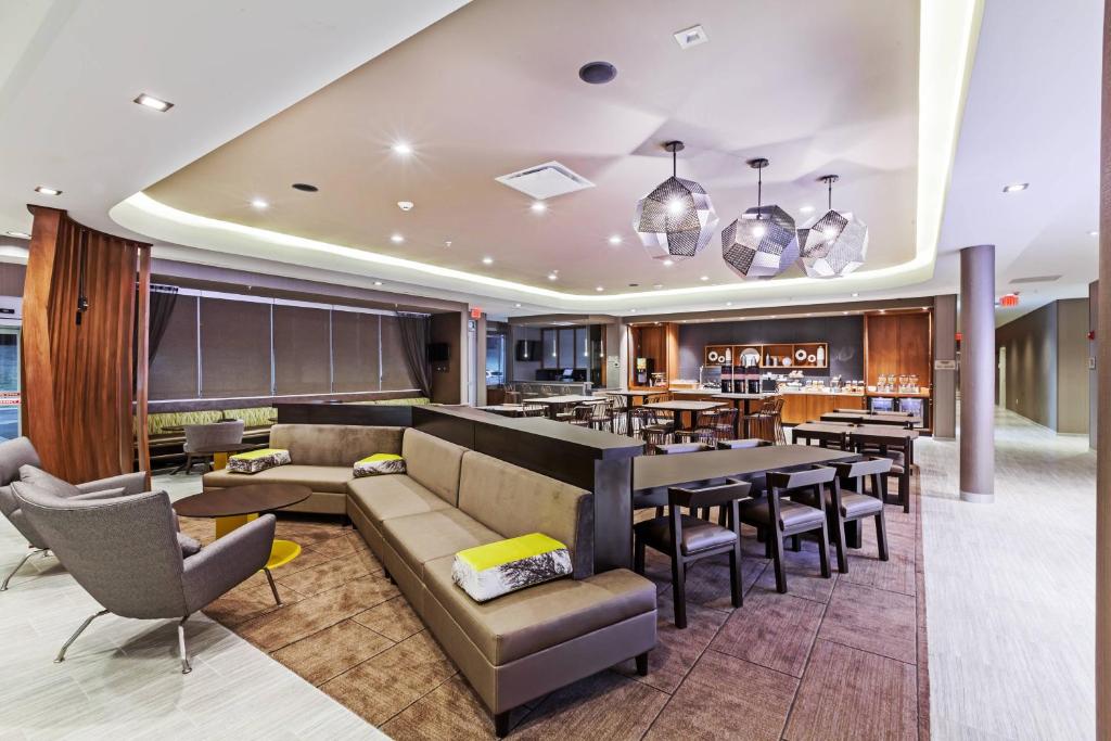 un restaurante con sofá, mesas y sillas en SpringHill Suites by Marriott Tulsa at Tulsa Hills, en Tulsa