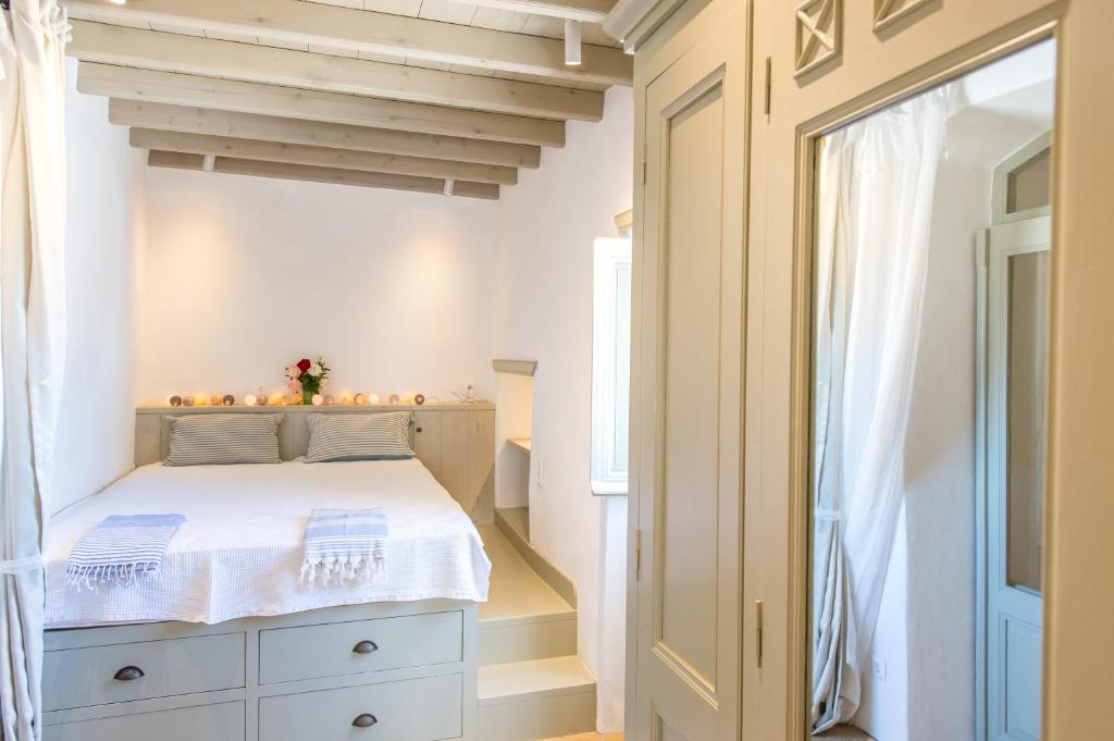 una camera con un letto bianco e una finestra di Patmos Traditional House Chora near the Monastery a Patmo (Patmos)