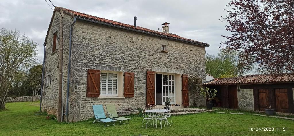 a house with a table and chairs in the yard at La maison de Marie in Verteuil-sur-Charente