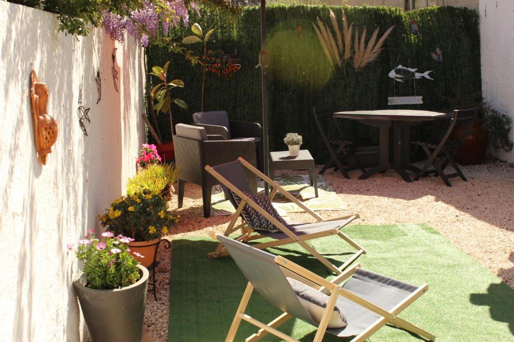 een patio met stoelen, een tafel en planten bij Studio avec Jardin et Parking Privés in Bormes-les-Mimosas