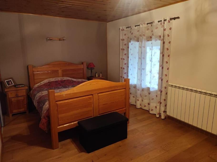 een slaapkamer met een houten bed en een raam bij Maison individuelle 5 personnes in Villar-Saint-Pancrace