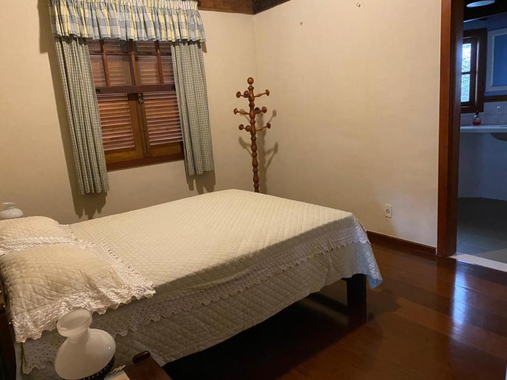 a bedroom with a bed and a window at Linda casa em Itaipava in Petrópolis