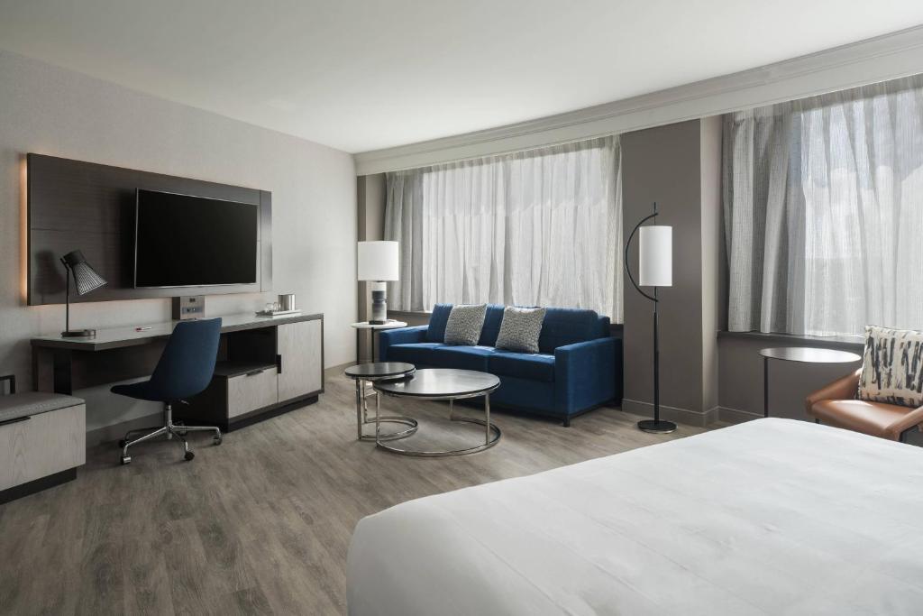 アーリントンにあるクリスタル シティ マリオット アット レーガン ナショナル エアポートのベッド、ソファ、テレビが備わるホテルルームです。