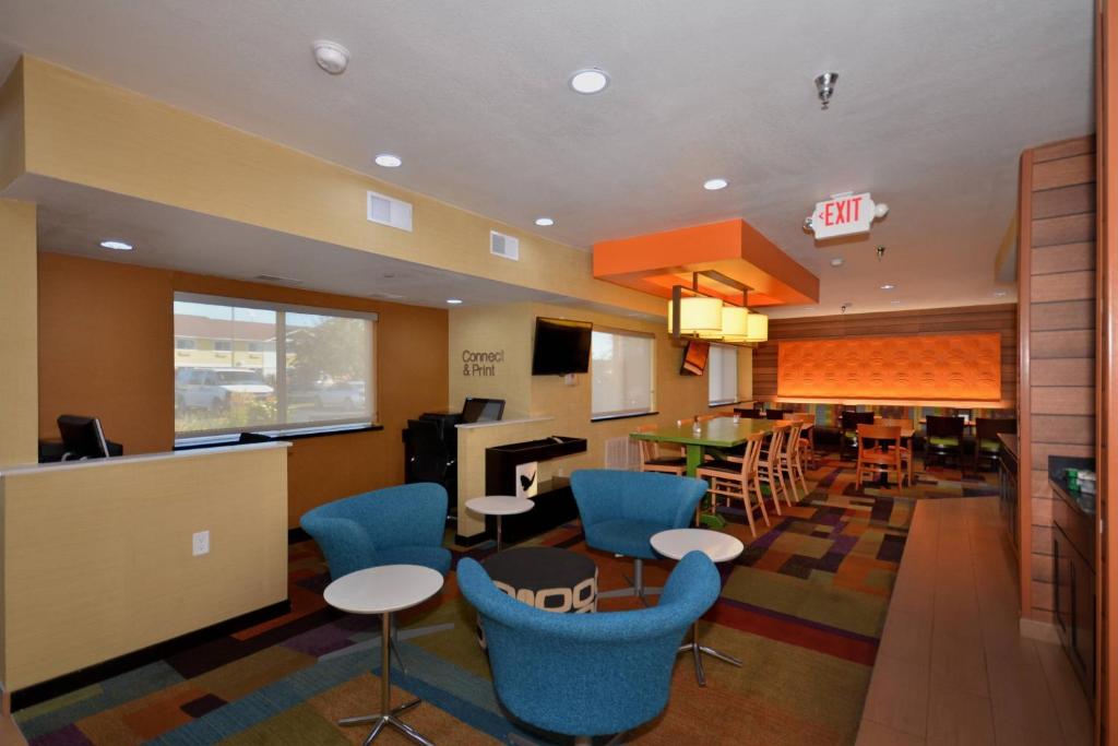 een woonkamer met blauwe stoelen en een eetkamer bij Spark by Hilton Springfield Southwest in Springfield