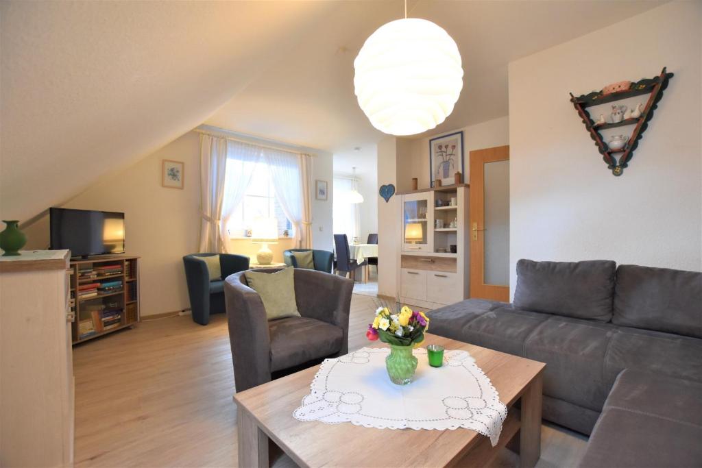 ein Wohnzimmer mit einem Sofa und einem Tisch in der Unterkunft Haus Antje-Kellenhusen Whg2 in Kellenhusen