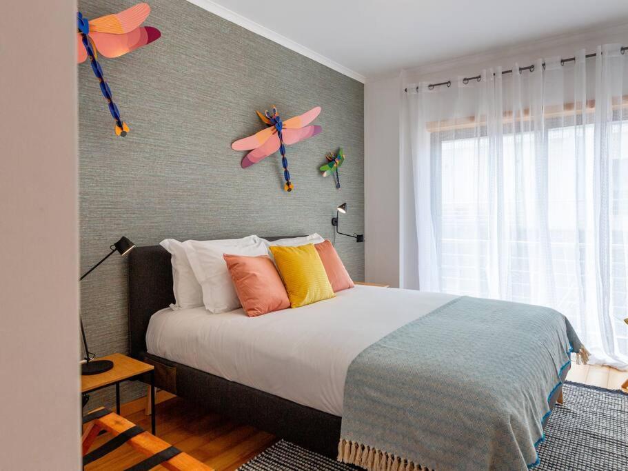 um quarto com uma cama com borboletas na parede em Central Caldas w/ AC & Fast Net nas Caldas da Rainha