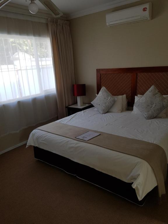 Postel nebo postele na pokoji v ubytování Ingwe Manor Guesthouse