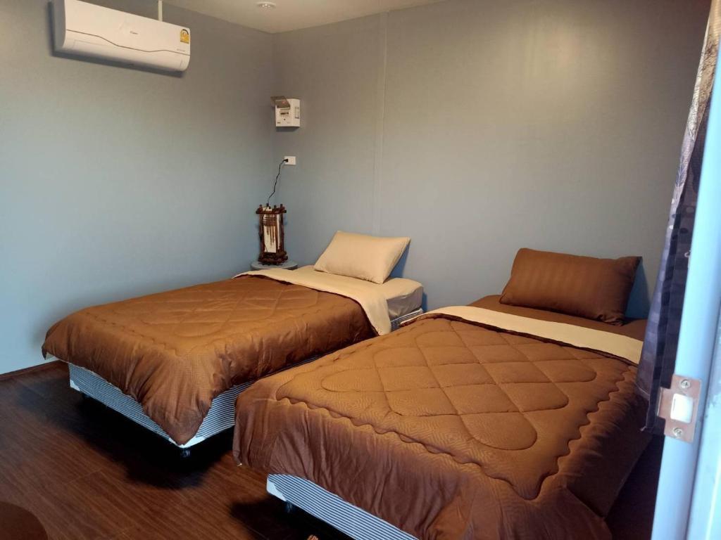 Habitación con 2 camas en una habitación en เฮือนพรนาคา โฮมสเตย์, en Ban Don Klang