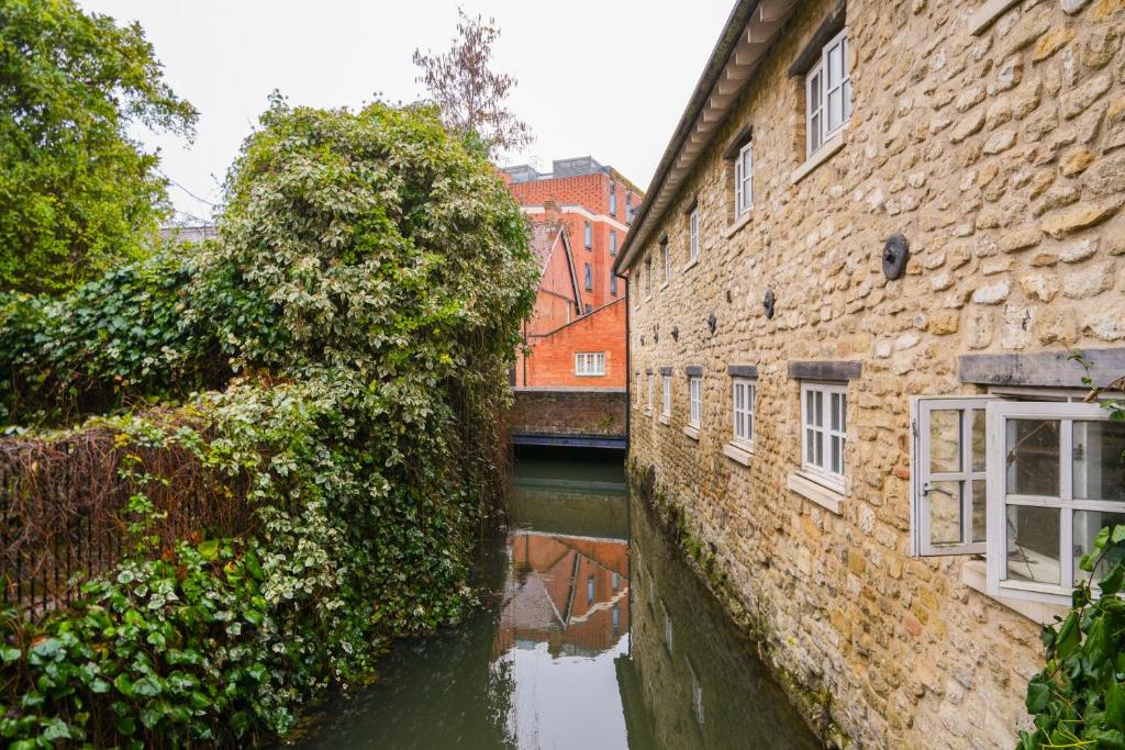 a canal between two buildings with ivy at Central but quiet in Oxford