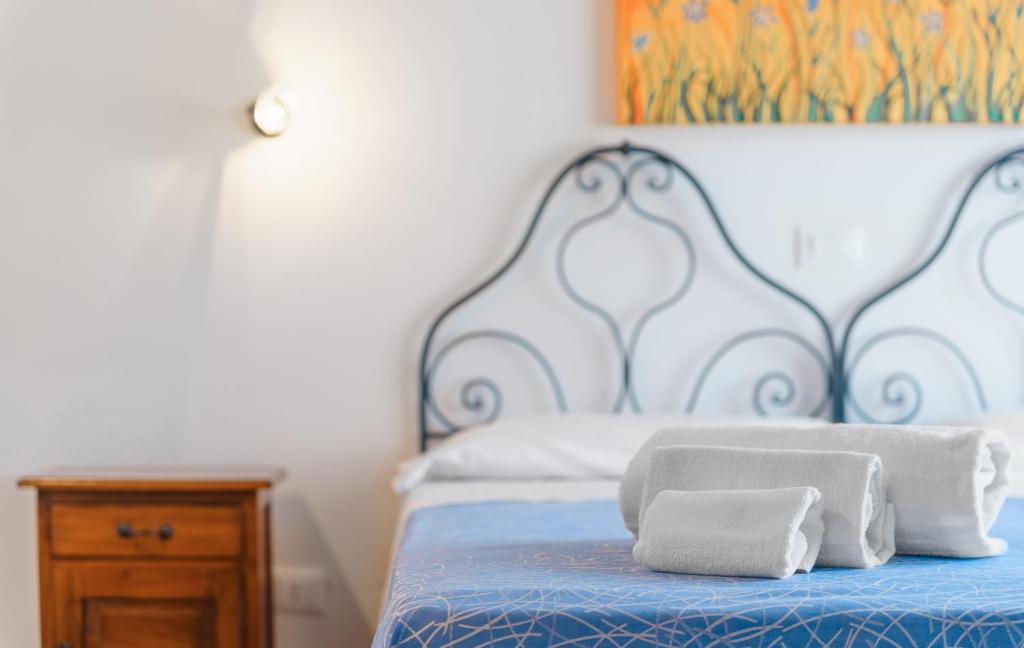 a bed with two towels sitting on top of it at Casale Ginisara in Castellammare del Golfo