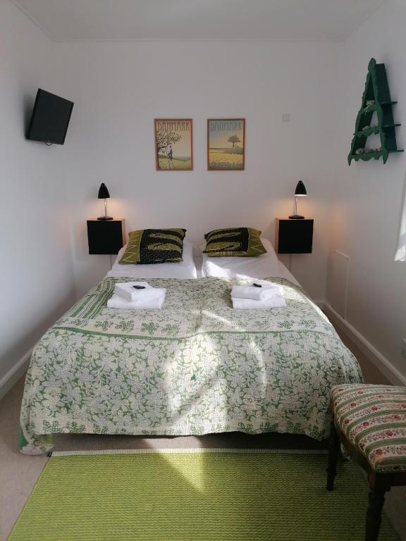 a bedroom with a large bed with two pillows at Femmasteren Hotel & Hostel in Marstal