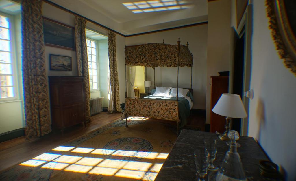- une chambre avec un lit à baldaquin et une fenêtre dans l'établissement Chateau du Fraisse, à Nouic